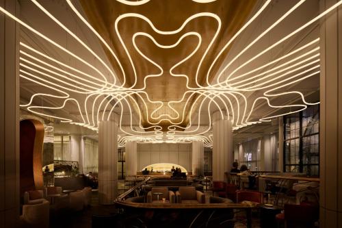 a lobby with a large chandelier in a building at The Playford Adelaide - MGallery in Adelaide