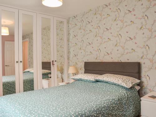 um quarto com uma cama e um espelho em Pine View em Mynyddislwyn