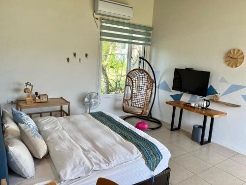 a bedroom with a bed and a flat screen tv at Mei Jung B&B in Zhixue