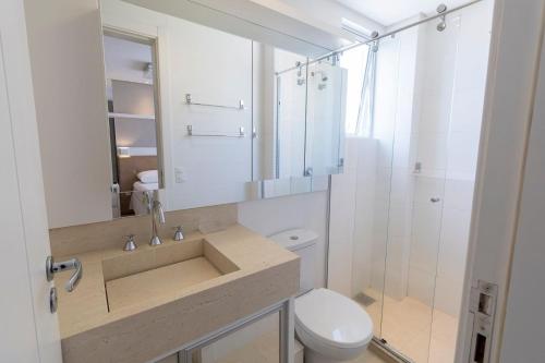 a bathroom with a sink and a toilet and a shower at Boulevard 221D - Excelente apartamento em condomínio de luxo no centro de Bombinhas - Piscina - Jacuzzi - Academia - Portaria 24h - (Consultar serviços de roupa de cama e banho) in Bombinhas