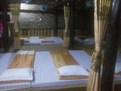 a group of beds in a room with curtains at Homestay Tuấn Nghĩa - Hang Phượng Hoàng - Võ Nhai in Hoan Chung
