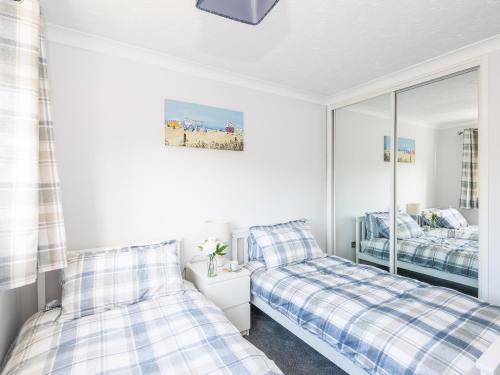 a bedroom with two beds and a mirror at Seascape in Sheringham