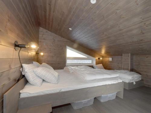 伊德烈的住宿－Holiday home IDRE III，一张位于带木制天花板的客房内的大床