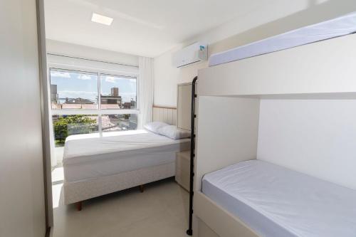 2 literas en una habitación con ventana en Puntarenas 202 - Excelente apartamento 2 suítes - Finamente mobiliado e decorado - À poucos metros da praia, en Bombinhas