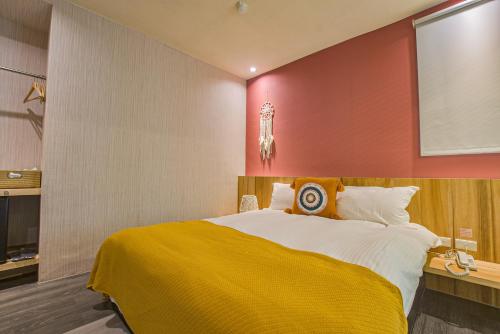 a bedroom with a large bed with a yellow blanket at Ashare Hotel in Jiaoxi