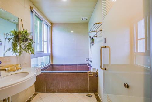 a bathroom with a tub and a sink and a shower at Ashare Hotel in Jiaoxi
