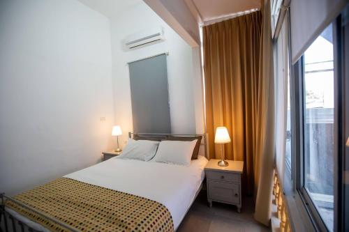 a bedroom with a bed and a large window at Berenice Winery Hotel in Tiberias