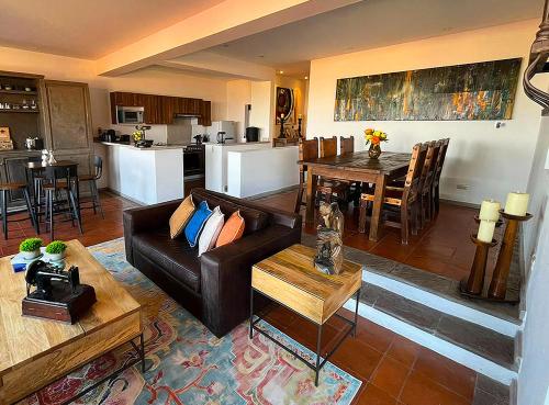 a living room with a couch and a table at Cousy Condo in the historic center of San Miguel de Allende, incredible view, pool, BBQ, 3 blocks from the main parish in San Miguel de Allende