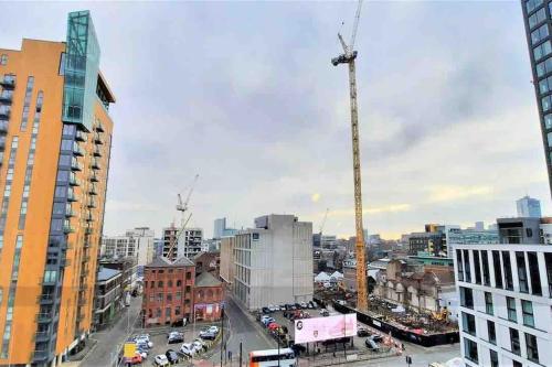 a view of a city with a construction crane at Stylish 2 bedroom apartment Manchester City centre in Manchester