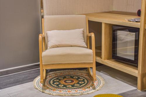 a chair sitting on a rug next to a table at Ashare Hotel in Jiaoxi