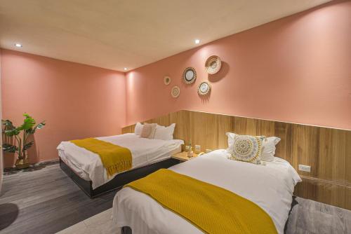 two beds in a hotel room with red walls at Ashare Hotel in Jiaoxi