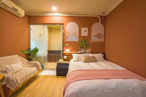a bedroom with a bed and a chair and a mirror at Ashare Hotel in Jiaoxi
