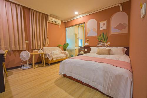 a bedroom with a large bed and a living room at Ashare Hotel in Jiaoxi