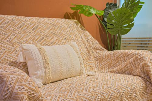 a couch with a pillow on it with a plant at Ashare Hotel in Jiaoxi