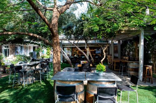 a patio with tables and chairs under a tree at Berenice Winery Hotel in Tiberias