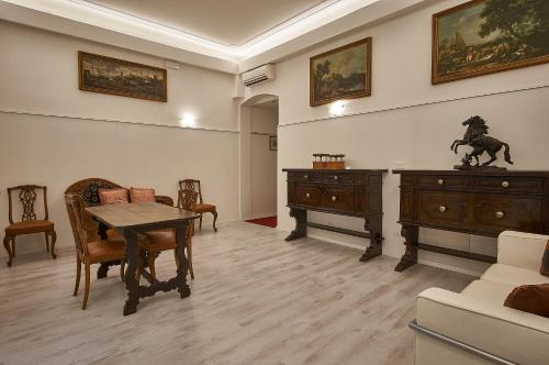 sala de estar con mesa, sillas y armario en Cuore di Bologna Suites, en Bolonia
