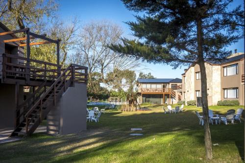a yard with chairs and a tree and a building at Ville Saint Germain Apart Hotel & Spa in Carilo