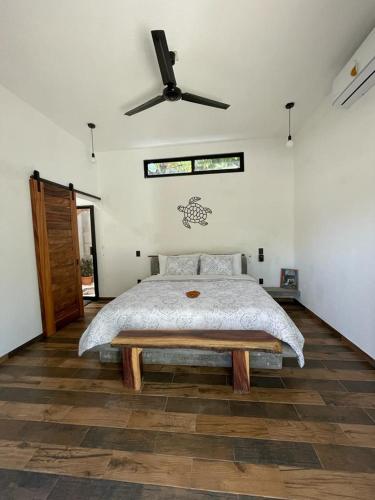 een slaapkamer met een bed en een plafondventilator bij Hostel Flakos in Zihuatanejo