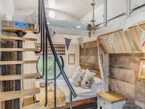 a tiny house with a staircase and a bed at Oak Tree Lodge in Stoke Fleming