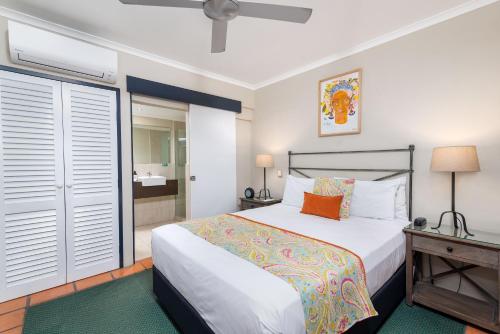a bedroom with a bed and a bathroom at Villa San Michele (Official) in Port Douglas