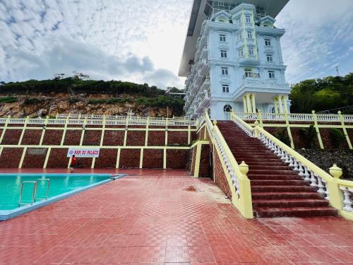 - un bâtiment avec une piscine à côté d'un bâtiment dans l'établissement NAM DU PALACE Hotel, à Nam Du