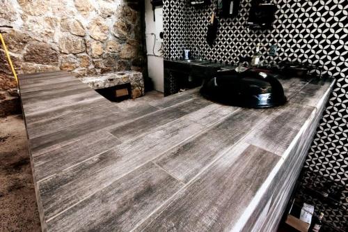 une salle de bains avec un sol en bois et un mur en pierre dans l'établissement Casa Aguila Gran Reserva, à Ixtapan de la Sal