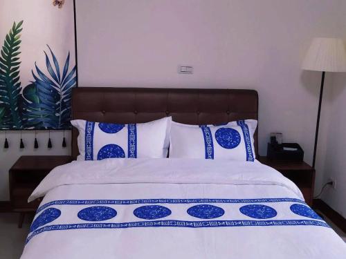 a bedroom with a bed with blue and white pillows at 親愛的民宿 in Jinning