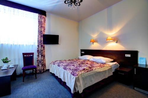 una stanza d'albergo con un letto e una sedia di Hostel Evotel a Zielonka