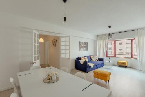a living room with a blue couch and a table at Elegant 3 bedroom apt - City centre - garage - metro in Lisbon