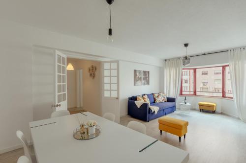uma sala de estar com um sofá azul e uma mesa em Elegant 3 bedroom apt - City centre - garage - metro em Lisboa