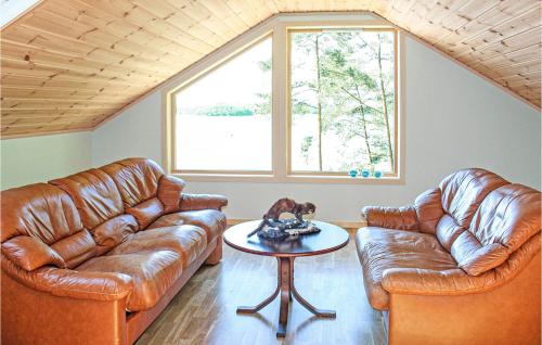 a living room with two leather couches and a table at Gorgeous Home In Hagavik in Hagavik