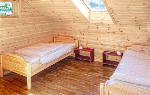 een slaapkamer met 2 bedden in een blokhut bij Awesome Home In Hagavik With House Sea View in Hagavik