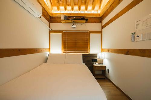 a bedroom with a white bed and a window at Luxury hanok with private bathtub - SN09 in Seoul