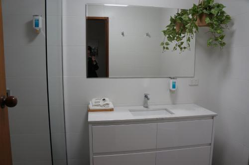 a bathroom with a sink and a mirror at Waves Motel and Apartments in Warrnambool