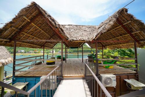 een paviljoen met een terras naast een waterlichaam bij Phong Nha Memory Homestay in Phong Nha