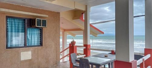 a balcony with a table and chairs and the ocean at Vista Aurora in Baler