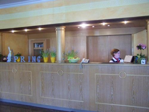 a woman sitting at a counter in a hotel lobby at Hotel Gerber in Hösbach