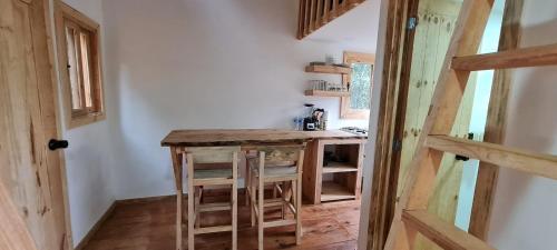 a kitchen with a wooden table in a room at Mariposa - Cabañas Puerto del Zopilote in Pinal de Amoles