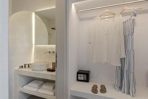 La salle de bains blanche est pourvue d'un lavabo et d'un miroir. dans l'établissement Onyx Hotel & Suites, à Karterados
