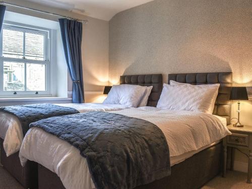 1 dormitorio con 2 camas y ventana en Primrose Cottage, en Grassington