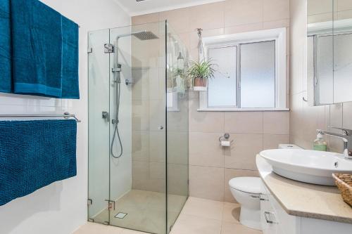 a bathroom with a shower and a toilet and a sink at Lazy Stays in Port Macquarie