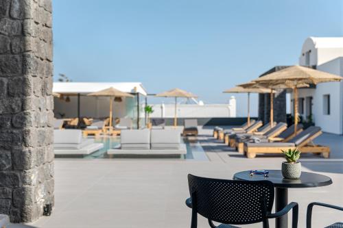 a patio with chairs and tables and umbrellas at Onyx Hotel & Suites in Karterados
