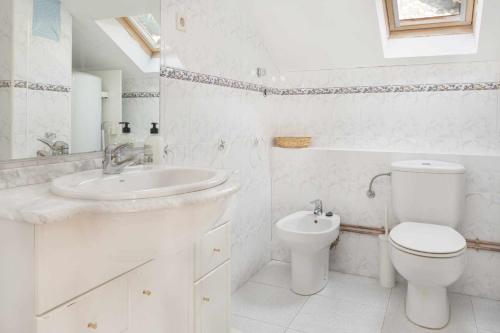 a white bathroom with a sink and a toilet at Ático B Residencial Caldares El Pueyo in El Pueyo de Jaca