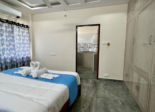a bedroom with a bed with towels and a mirror at TrueLife - Bhavya Manor - Breakfast Included - 2500 SFT Modern homes with Garden - Panorama Tirumala Mountain View - Peaceful Location - Fast WiFi - Many restaurants nearby - Large hall, AC bedrooms, Kitchen - Android TV - Top service with lots of Love in Tirupati