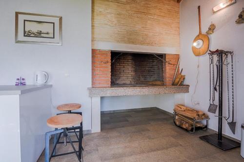 sala de estar con chimenea de ladrillo y 2 taburetes en Apartments Basic Vesna en Vir