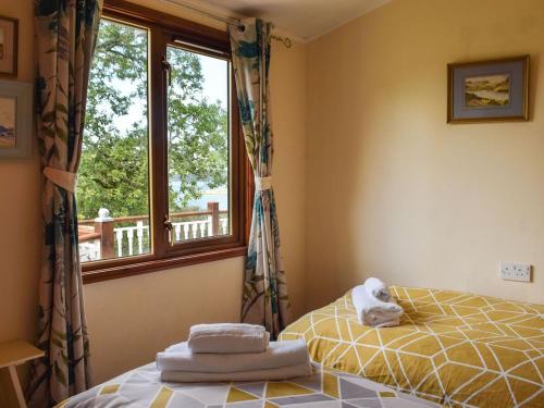 a bedroom with a bed and a window at Teasel Lodge - Uk39647 in Lunga