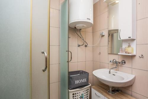 Un baño pequeño con lavabo y espejo. en Apartments Horvatic, en Vir