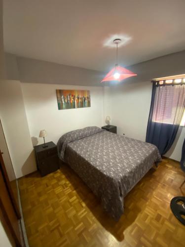 1 dormitorio con 1 cama y luz roja en Departamento Aconcagua en Mendoza