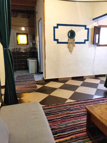 a living room with a checkered floor and a couch at Moudy’s House in Dahab