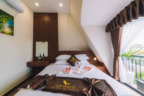 a bedroom with a bed with a large window at GREENECO DA LAT HOTEL - Khách sạn Green Eco Đà Lạt in Da Lat